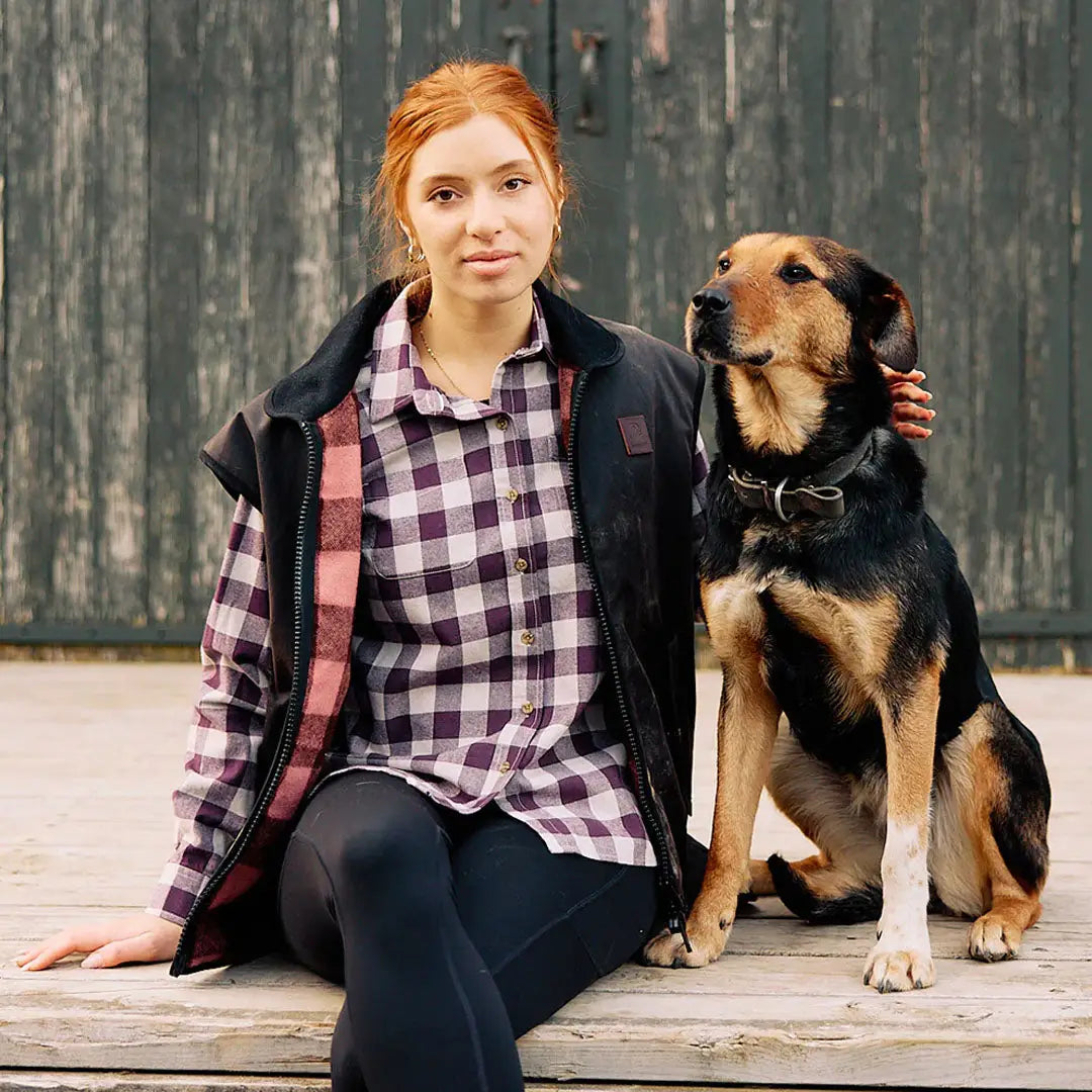 A woman with auburn hair in Swanndri High Rock Womens Legging sitting with a black and tan dog
