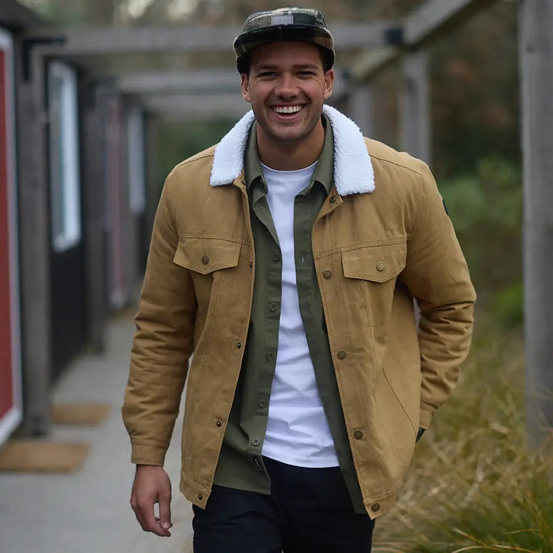 Men’s tan Swanndri Kaituna Mens Canvas Jacket layered over green shirt and white tee