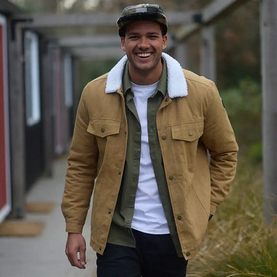 Men’s tan Swanndri Kaituna Mens Canvas Jacket layered over green shirt and white tee