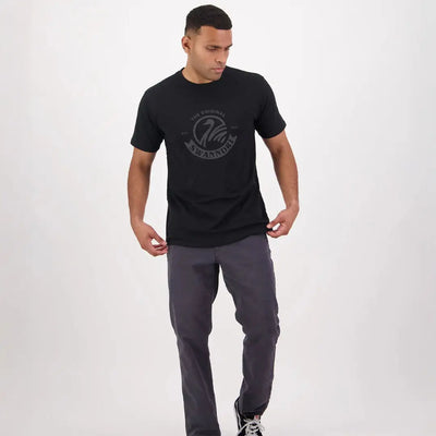 Man in a black t-shirt and gray pants showcasing the Swanndri Original V2 Printed Tee