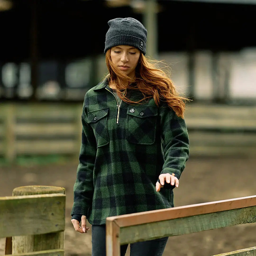 Woman in dark green plaid Swanndri Ranger Womens bush shirt and gray beanie outdoors