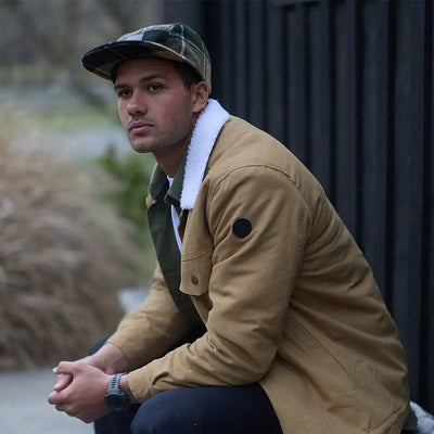 Man wearing Swanndri Wentworth Valley V2 Wool Cap with plaid cap and tan jacket