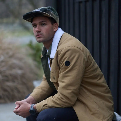 Man wearing Swanndri Wentworth Valley V2 Wool Cap with plaid cap and tan jacket