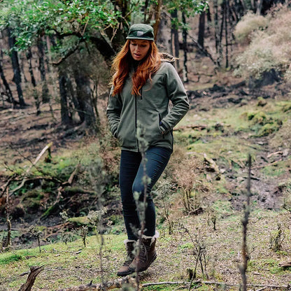 Woman in green high rock zip water resistant recycled fleece hoodie in forest scene