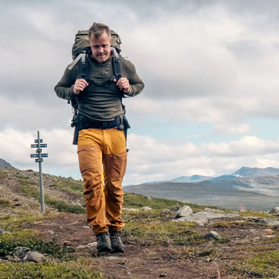 Hiker in Woolpower Zip Turtleneck enjoys the outdoors on a mountain trail