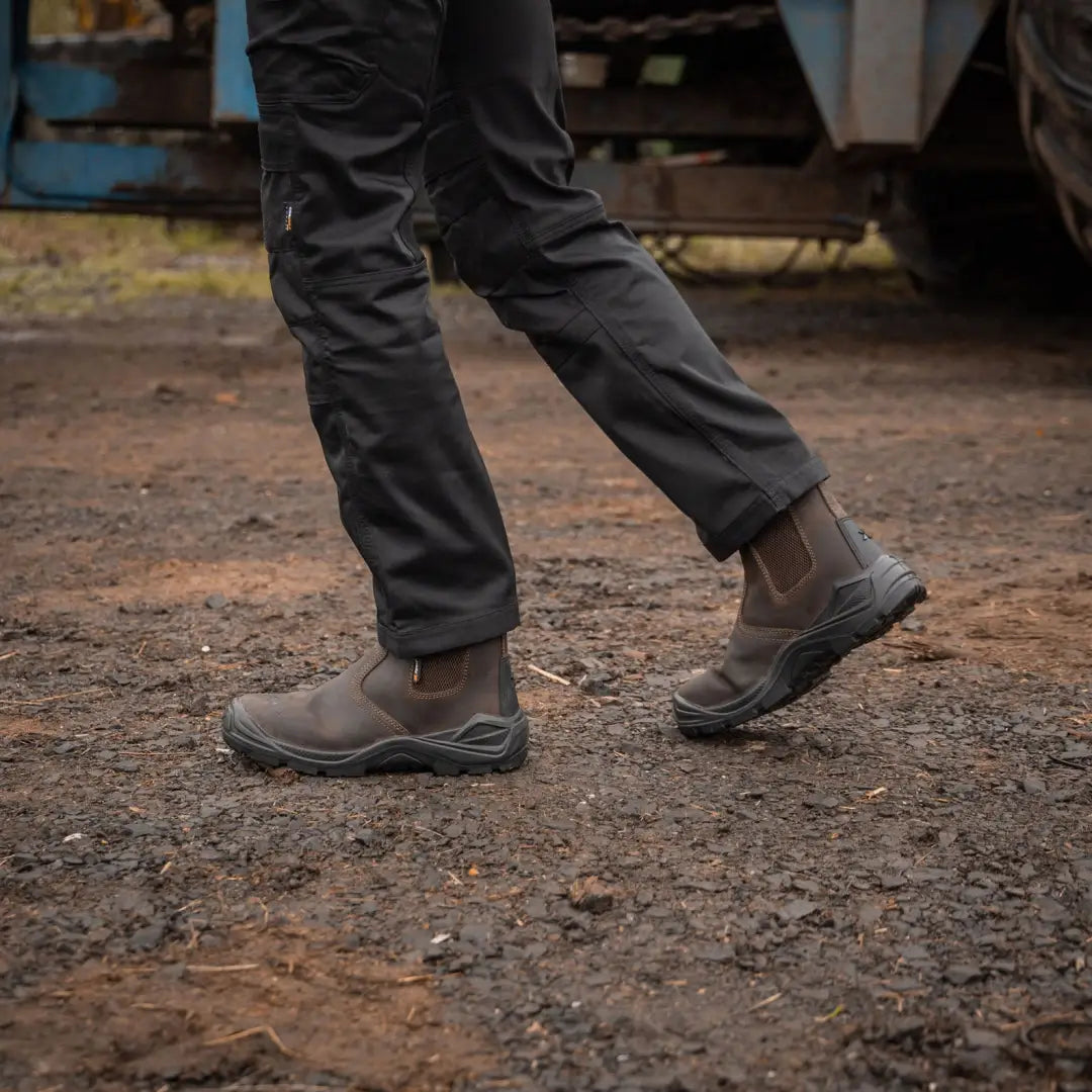Brown leather Xpert Defiant S3 Safety Dealer Boot on feet with black soles