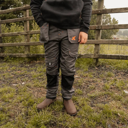 Kid’s grey and black Xpert Pro Junior Stretch Work Trouser with pockets and brown boots